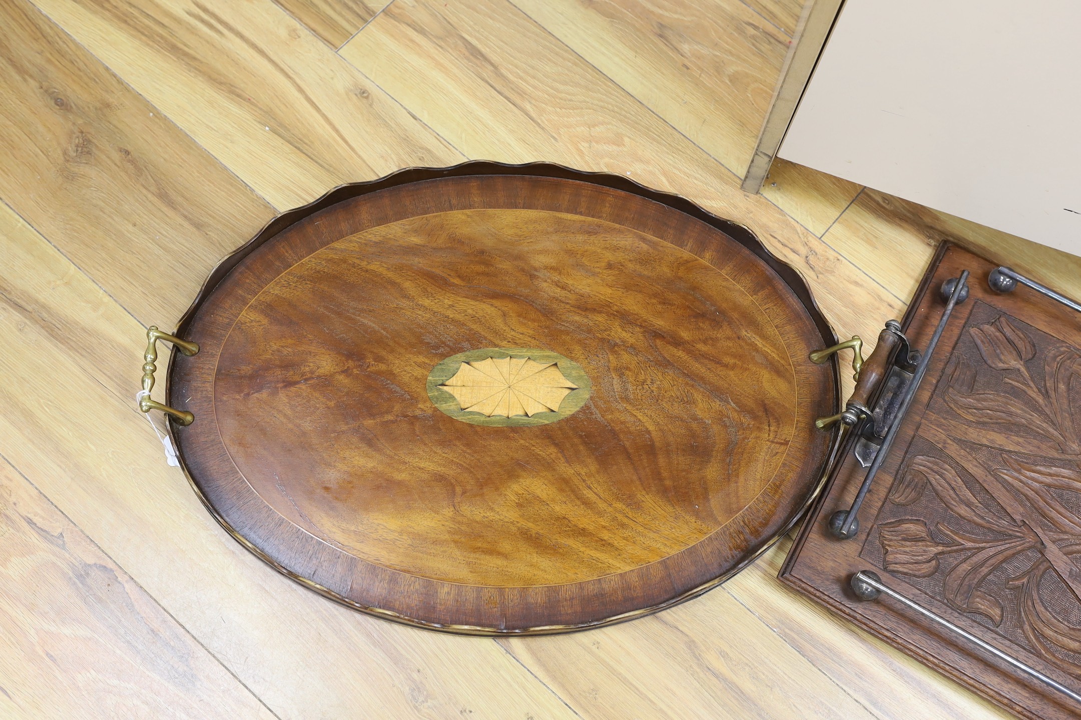 An oval, shell inlaid, pie crust tray and a carved oak rectangular tray, with chrome gallery and handles, oak tray 67 cms wide.